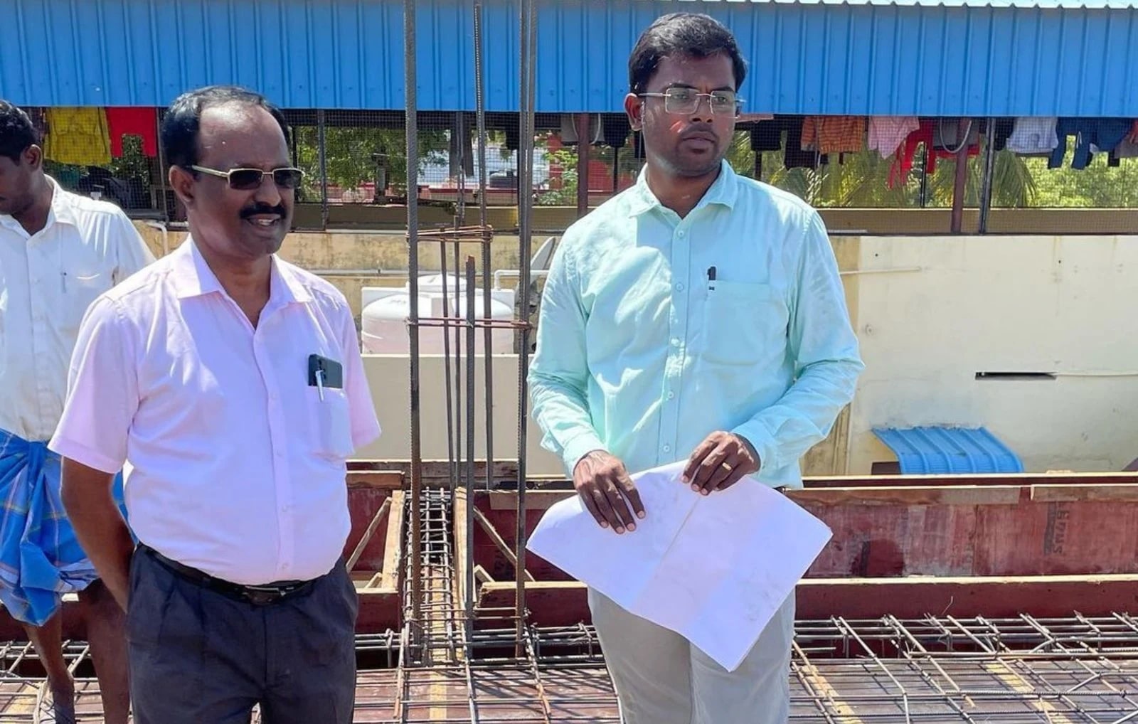 Engineers discussing drawings at a site in Anugraha’s project archive